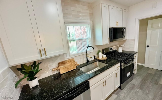 16721 Lomond Blvd, Shaker Heights, OH 44120 - kitchen with stainless steel appliances, white cabinets, dark stone counters, backsplash, and wood finished floors