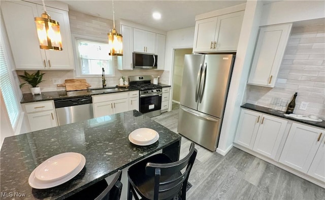 16721 Lomond Blvd, Shaker Heights, OH 44120 - kitchen with stainless steel appliances, backsplash, light wood-style floors, and white cabinetry