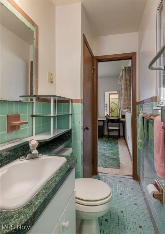 7080 Arcadia Dr, Parma, OH 44129 - bathroom with tile walls, vanity, wainscoting, and tile patterned floors