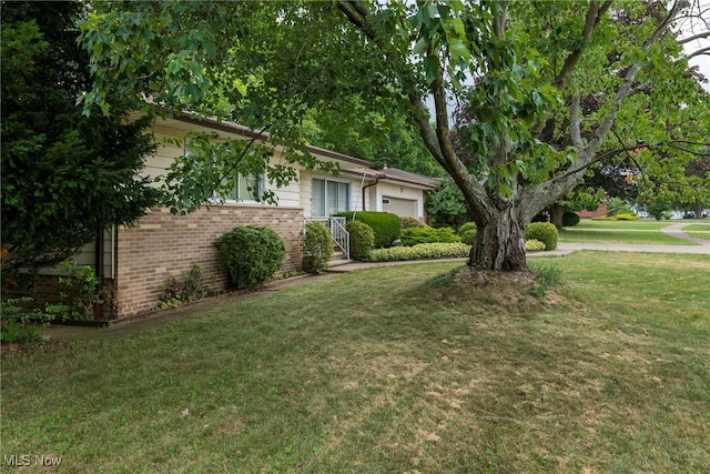 7080 Arcadia Dr, Parma, OH 44129 - view of front of property with an attached garage, brick siding, and a front yard