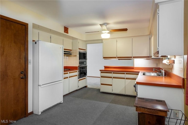 7080 Arcadia Dr, Parma, OH 44129 - kitchen with freestanding refrigerator, black oven, stainless steel microwave, a ceiling fan, and decorative backsplash
