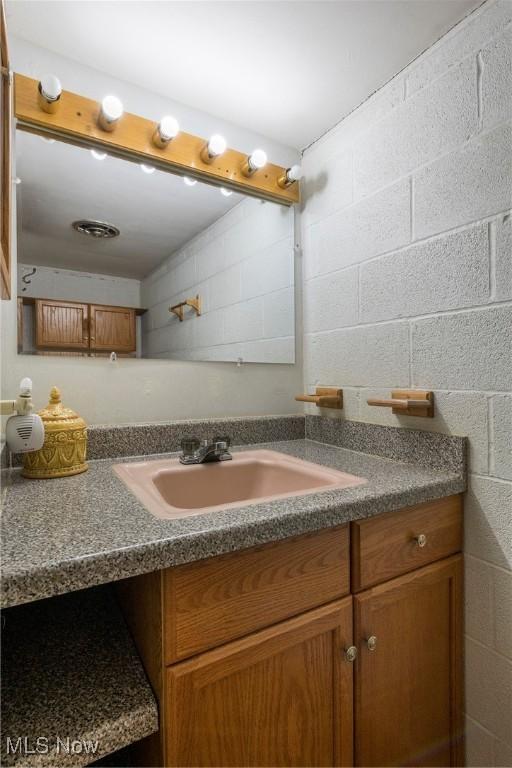 7080 Arcadia Dr, Parma, OH 44129 - bathroom featuring vanity and concrete block wall