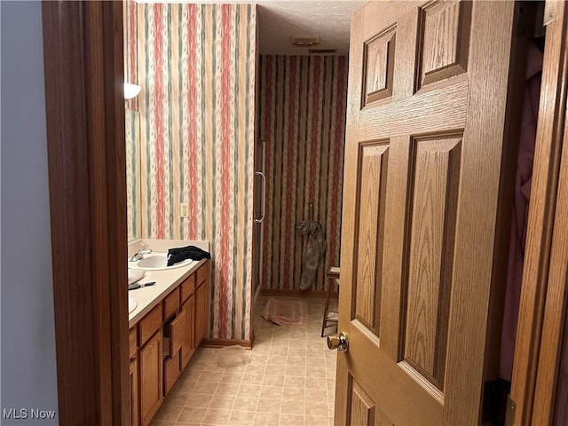 16199 Emerald Pt, Middleburg Heights, OH 44130 - full bath featuring wallpapered walls, double vanity, and a textured ceiling