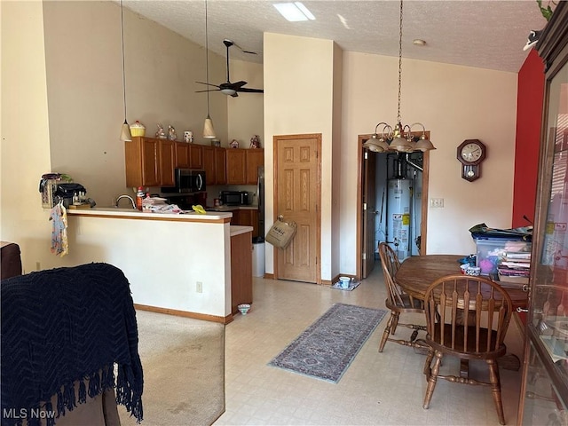 16199 Emerald Pt, Middleburg Heights, OH 44130 - kitchen featuring stainless steel microwave, brown cabinetry, light floors, water heater, and high vaulted ceiling
