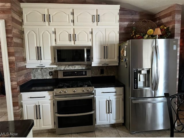1995 Fox Chase, Youngstown, OH 44515 - kitchen featuring appliances with stainless steel finishes, dark countertops, white cabinets, tasteful backsplash, and wooden walls