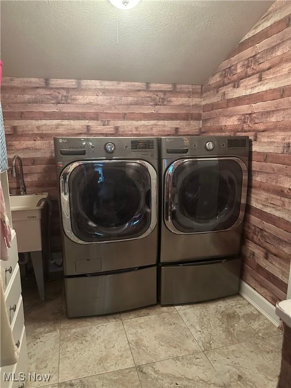 1995 Fox Chase, Youngstown, OH 44515 - laundry area featuring independent washer and dryer, wooden walls, a textured ceiling, and light stone finish floors