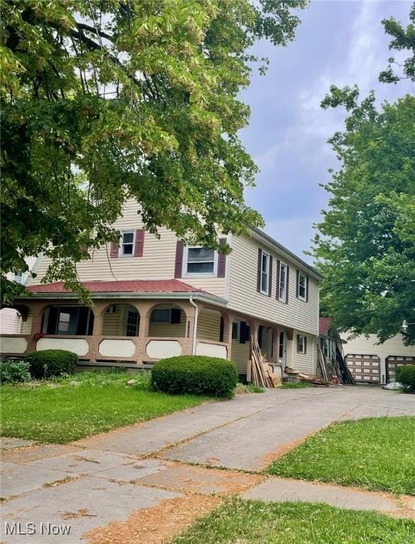 1709 E 29th St, Lorain, OH 44055 - view of front facade with a garage and a front lawn