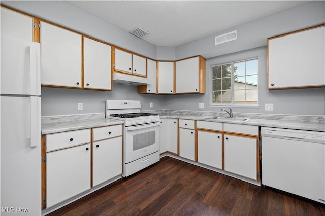 27087 Oakwood Cir Unit 102Y, Olmsted Twp, OH 44138 - kitchen with white appliances, under cabinet range hood, light countertops, dark wood-style floors, and white cabinetry