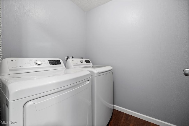 27087 Oakwood Cir Unit 102Y, Olmsted Twp, OH 44138 - laundry area featuring washing machine and clothes dryer and dark wood-style flooring