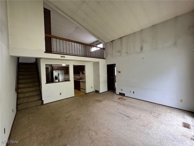 5436 Summerwood Ct Unit C, Willoughby, OH 44094 - unfurnished living room featuring high vaulted ceiling, carpet flooring, and stairway