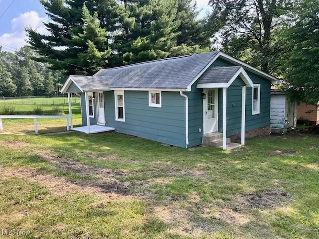 713 N 7th St, Bergholz, OH 43908 - view of front facade featuring a front yard, roof with shingles, and entry steps