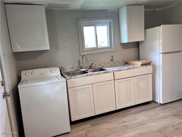 713 N 7th St, Bergholz, OH 43908 - kitchen with washer / dryer, freestanding refrigerator, light wood finished floors, light countertops, and white cabinetry