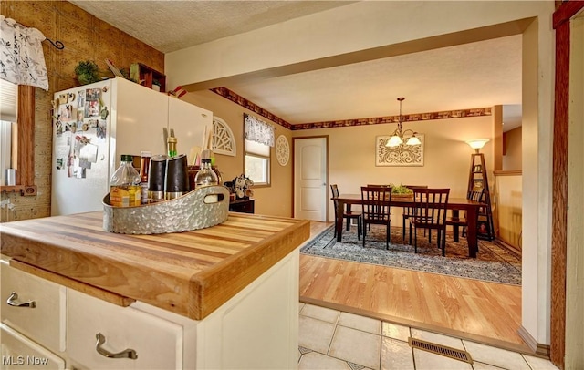 99 Mccook Ave, Carrollton, OH 44615 - kitchen with freestanding refrigerator, light tile patterned floors, a chandelier, and hanging light fixtures