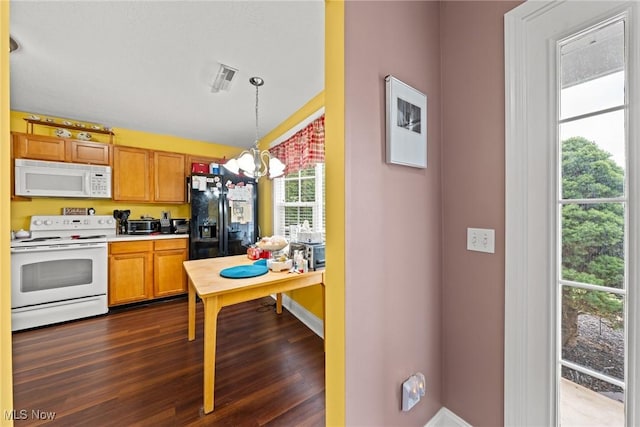 1446 Chesapeake Ave, Louisville, OH 44641 - kitchen with white appliances, a chandelier, dark wood-style flooring, light countertops, and pendant lighting