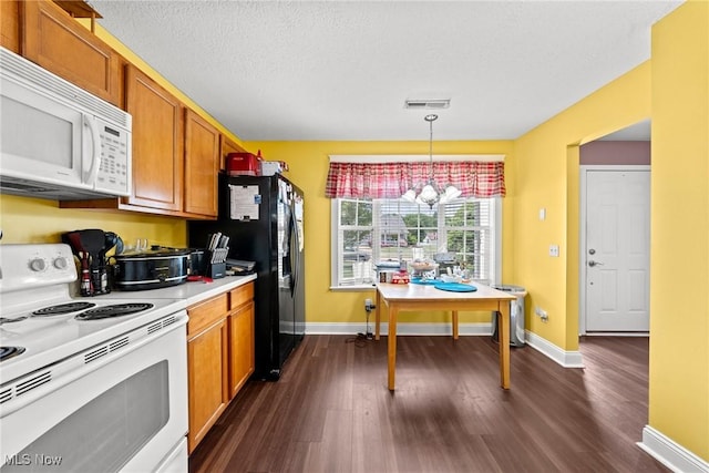 1446 Chesapeake Ave, Louisville, OH 44641 - kitchen with white appliances, dark wood-style flooring, a chandelier, light countertops, and decorative light fixtures