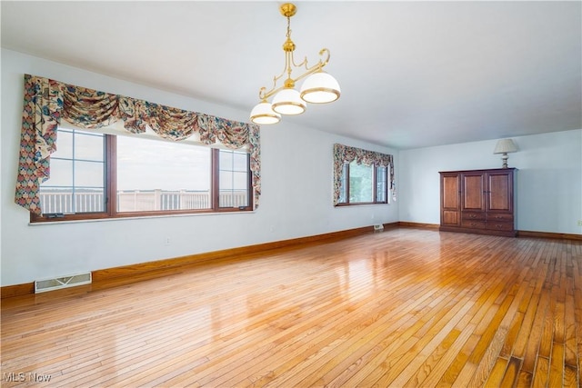 3945 Palisades Dr, Weirton, WV 26062 - empty room featuring light wood-style floors and a chandelier