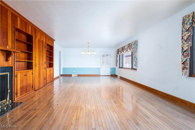 3945 Palisades Dr, Weirton, WV 26062 - unfurnished living room with a chandelier, light wood finished floors, a fireplace, and built in features