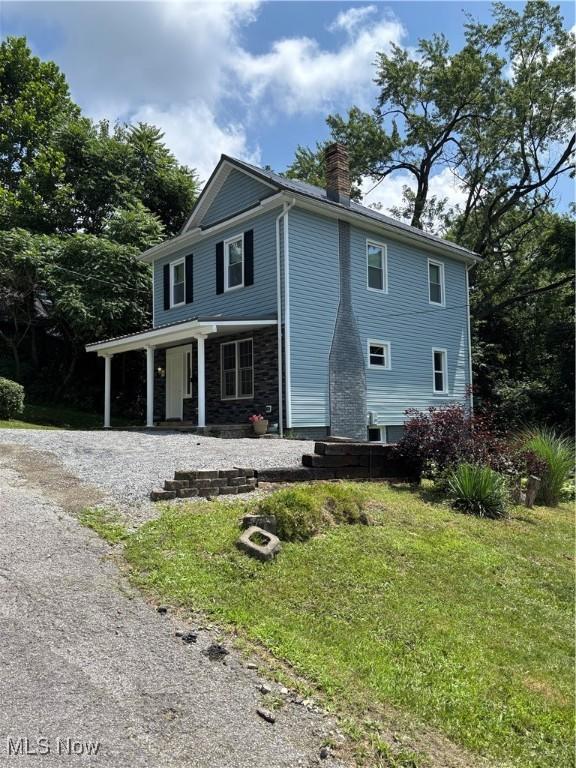 600 Marcus St, East Liverpool, OH 43920 - view of home's exterior featuring a chimney, a lawn, a porch, and driveway