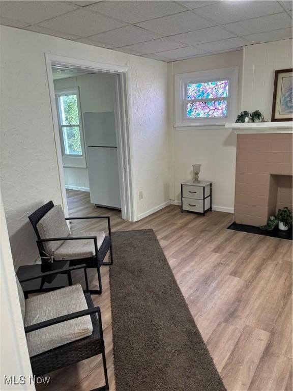 600 Marcus St, East Liverpool, OH 43920 - living area featuring light wood finished floors, a drop ceiling, a fireplace with flush hearth, and a textured wall