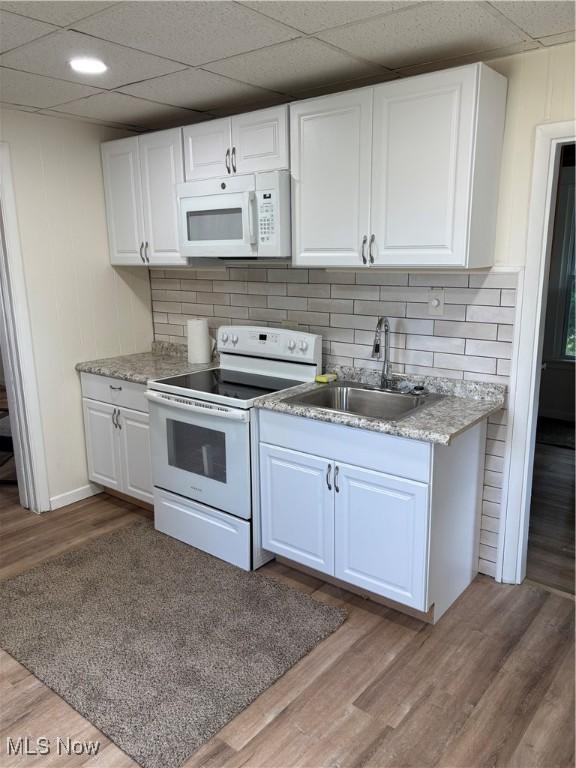 600 Marcus St, East Liverpool, OH 43920 - kitchen with white appliances, a drop ceiling, backsplash, white cabinetry, and wood finished floors