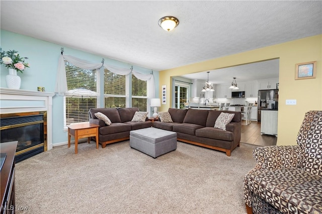 9034 Huxley Ln, Olmsted Twp, OH 44138 - living room with a chandelier, carpet flooring, and a glass covered fireplace
