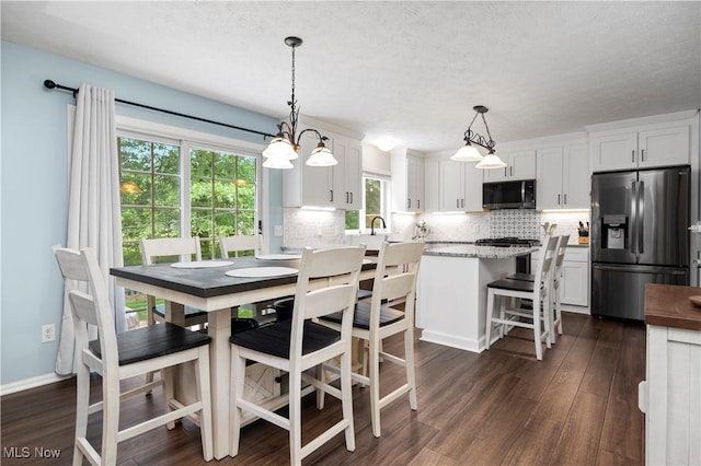 9034 Huxley Ln, Olmsted Twp, OH 44138 - dining space featuring dark wood finished floors and a textured ceiling