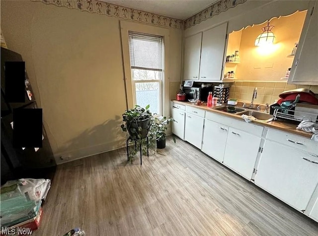 574 Spring St, Struthers, OH 44471 - kitchen featuring light wood-type flooring, white cabinets, tasteful backsplash, and open shelves