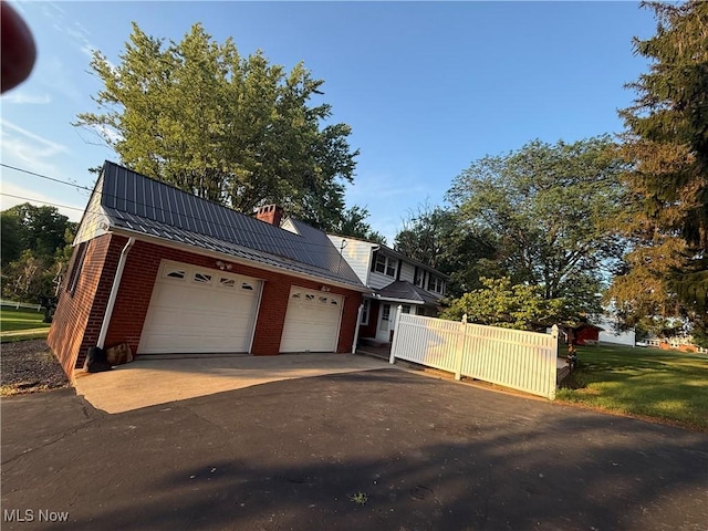 62239 Hillcrest Rd, Barnesville, OH 43713 - view of front of house with asphalt driveway, brick siding, an attached garage, a metal roof, and a chimney