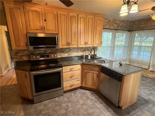62239 Hillcrest Rd, Barnesville, OH 43713 - kitchen featuring appliances with stainless steel finishes, a ceiling fan, a peninsula, backsplash, and dark stone countertops