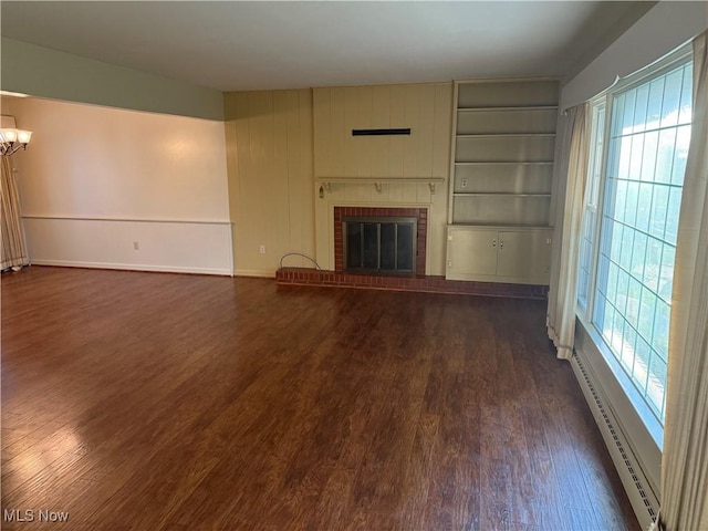 62239 Hillcrest Rd, Barnesville, OH 43713 - unfurnished living room featuring baseboard heating, dark wood-type flooring, plenty of natural light, and a chandelier