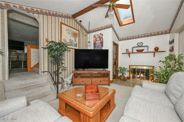 1266 Pitkin Ave, Akron, OH 44310 - living room featuring carpet floors, ceiling fan, a glass covered fireplace, a skylight, and stairway