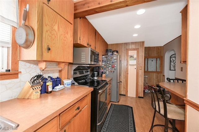 1266 Pitkin Ave, Akron, OH 44310 - kitchen with stainless steel appliances, light countertops, backsplash, light wood finished floors, and wood walls