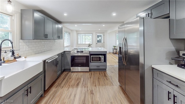 3187 Grenfall Rd, Norton, OH 44203 - kitchen featuring appliances with stainless steel finishes, light wood finished floors, gray cabinetry, a peninsula, and light countertops