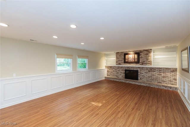 2271 Augusta Ct, Westlake, OH 44145 - unfurnished living room featuring a fireplace, wood finished floors, wainscoting, recessed lighting, and a decorative wall