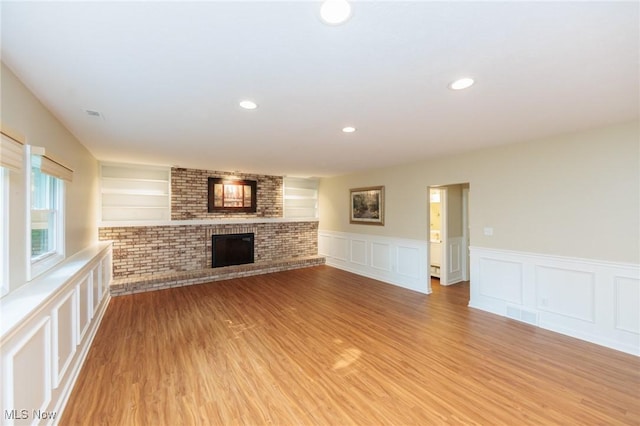 2271 Augusta Ct, Westlake, OH 44145 - unfurnished living room with wainscoting, light wood-style floors, a brick fireplace, and recessed lighting
