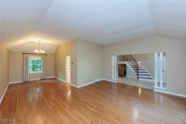 2271 Augusta Ct, Westlake, OH 44145 - unfurnished living room featuring lofted ceiling, a chandelier, stairway, and wood finished floors