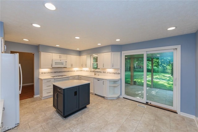 2271 Augusta Ct, Westlake, OH 44145 - kitchen featuring white appliances, white cabinetry, light countertops, tasteful backsplash, and a kitchen island