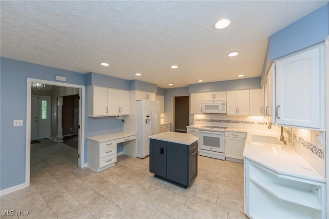 2271 Augusta Ct, Westlake, OH 44145 - kitchen featuring white appliances, white cabinets, tasteful backsplash, a kitchen island, and light countertops