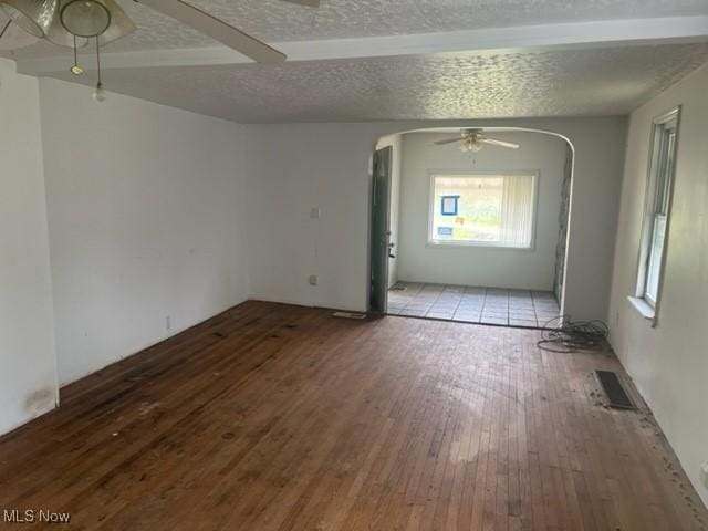 70610 Chermont Rd, Bridgeport, OH 43912 - empty room featuring a ceiling fan, arched walkways, wood-type flooring, and a textured ceiling