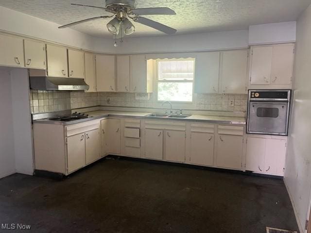 70610 Chermont Rd, Bridgeport, OH 43912 - kitchen featuring stainless steel appliances, under cabinet range hood, light countertops, tasteful backsplash, and a textured ceiling