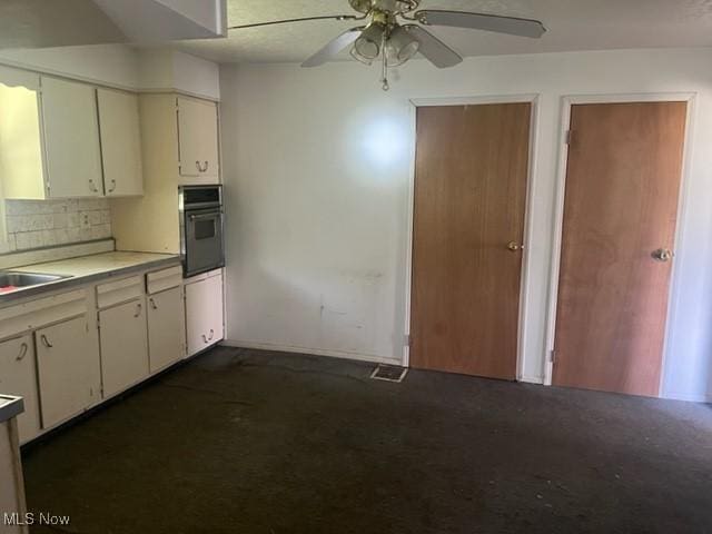 70610 Chermont Rd, Bridgeport, OH 43912 - kitchen with oven, ceiling fan, light countertops, dark colored carpet, and white cabinets