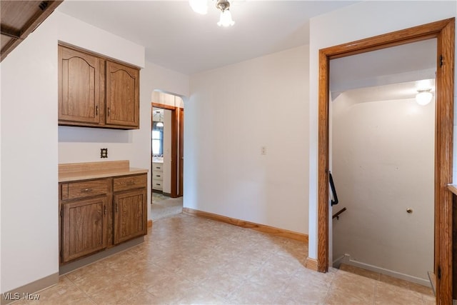 1403 Wexford Ave, Parma, OH 44134 - kitchen featuring arched walkways, light countertops, and brown cabinetry