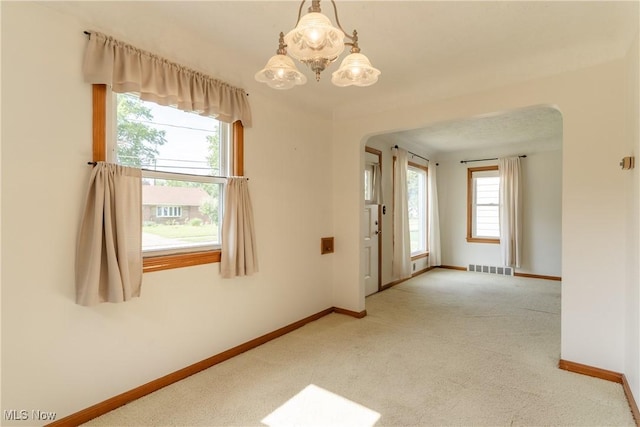 1403 Wexford Ave, Parma, OH 44134 - carpeted spare room with arched walkways and a chandelier