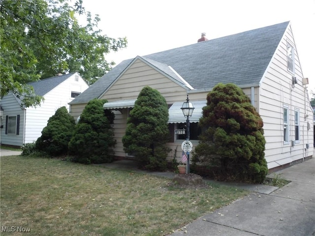 373 E 232nd St, Euclid, OH 44123 - view of side of property with a lawn, a chimney, and a shingled roof