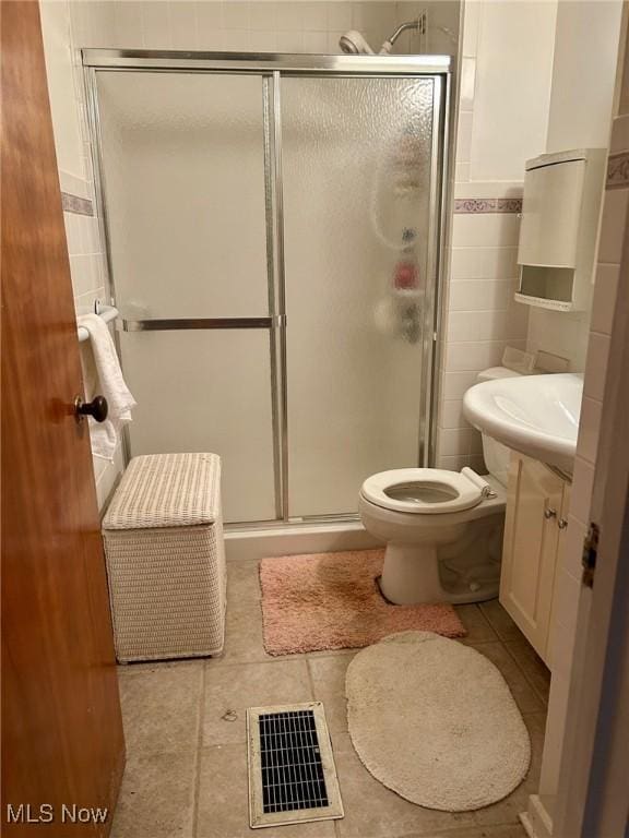 330 Inwood Blvd, Avon Lake, OH 44012 - full bath featuring vanity, a shower stall, tile walls, tile patterned floors, and a wainscoted wall