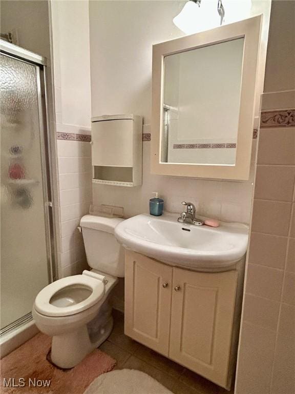 330 Inwood Blvd, Avon Lake, OH 44012 - full bathroom with tile walls, a stall shower, vanity, tile patterned floors, and a wainscoted wall