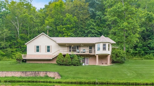 4101 Oak Ridge Ln, Cambridge, OH 43725 - back of house featuring a lawn, a deck, and a wooded view