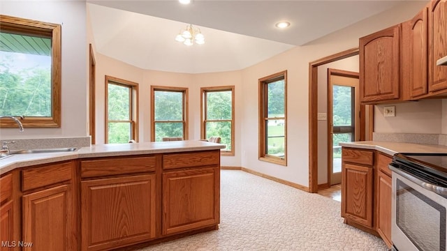 4101 Oak Ridge Ln, Cambridge, OH 43725 - kitchen with stainless steel electric range, light countertops, brown cabinetry, light colored carpet, and a chandelier
