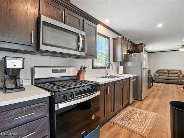 187 Garfield Ln, Jefferson, OH 44047 - kitchen with appliances with stainless steel finishes, dark brown cabinets, light countertops, light wood-style floors, and crown molding