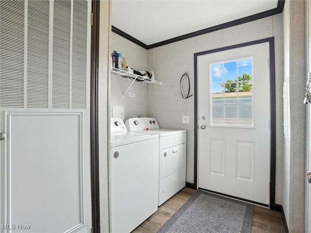 187 Garfield Ln, Jefferson, OH 44047 - laundry area featuring washing machine and dryer, ornamental molding, a heating unit, and light wood-style flooring